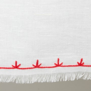 Pequeño mantel artesanal con detalle en rojo