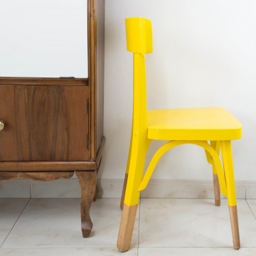 Antigua silla escolar restaurada en amarillo
